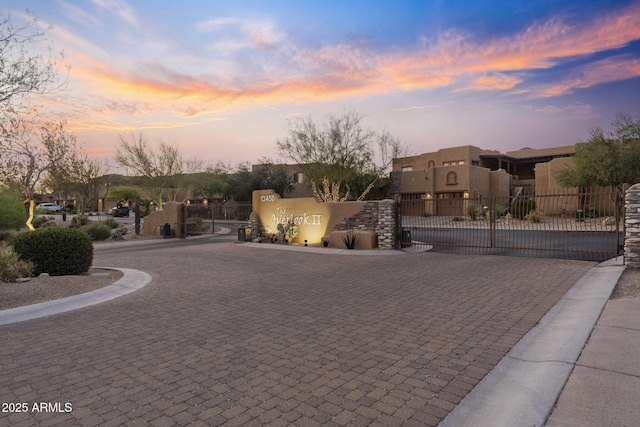 exterior space featuring a residential view, a gate, stucco siding, and fence