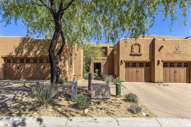 southwest-style home with an attached garage, stucco siding, and concrete driveway