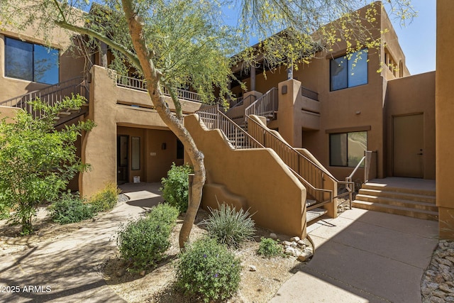 exterior space featuring stairs and stucco siding