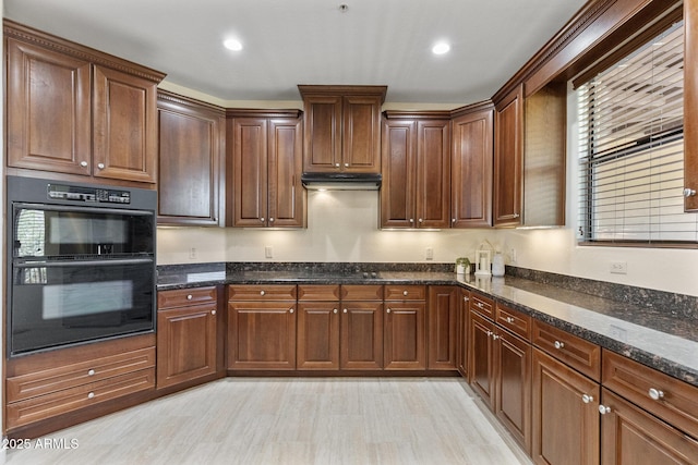 kitchen featuring recessed lighting, dark stone counters, under cabinet range hood, and black appliances