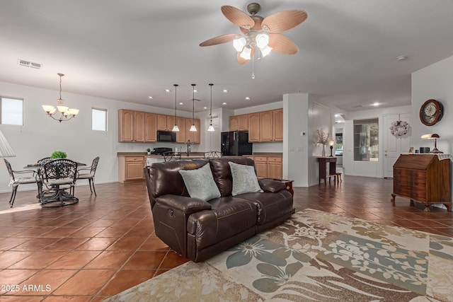 3023 E Silversmith Trl, San Tan Valley, AZ 85143 - living area featuring recessed lighting, visible vents, dark tile patterned flooring, and ceiling fan with notable chandelier