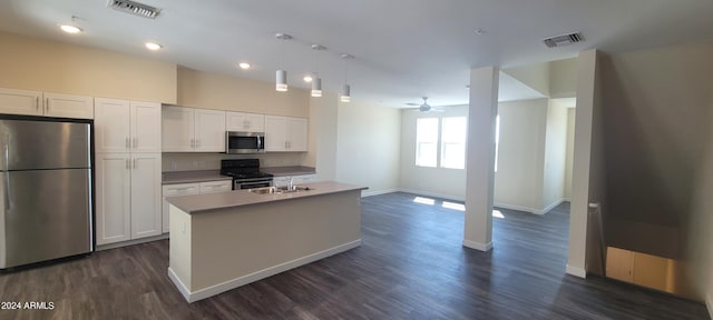 kitchen featuring visible vents, dark wood finished floors, an island with sink, stainless steel appliances, and white cabinetry