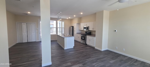 kitchen with open floor plan, appliances with stainless steel finishes, and white cabinets