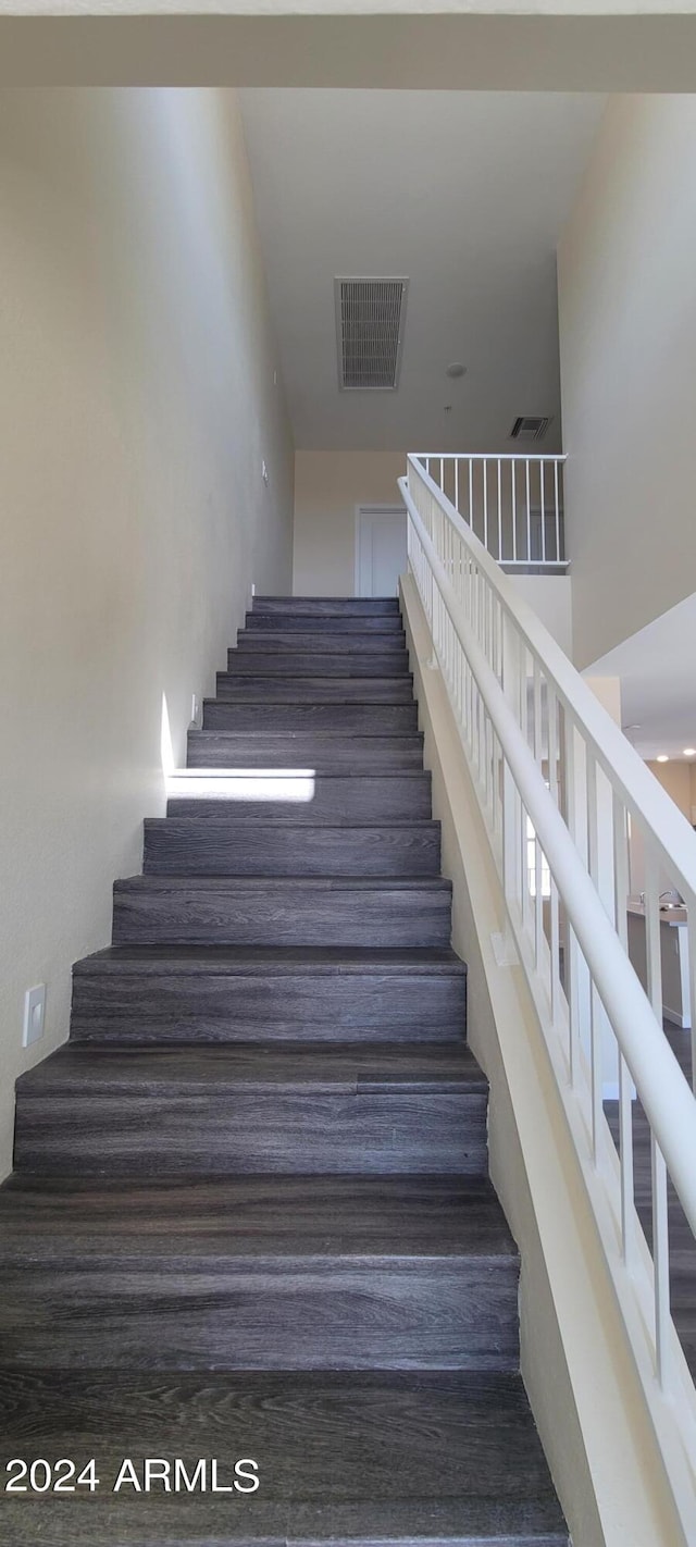 stairs featuring visible vents and a high ceiling