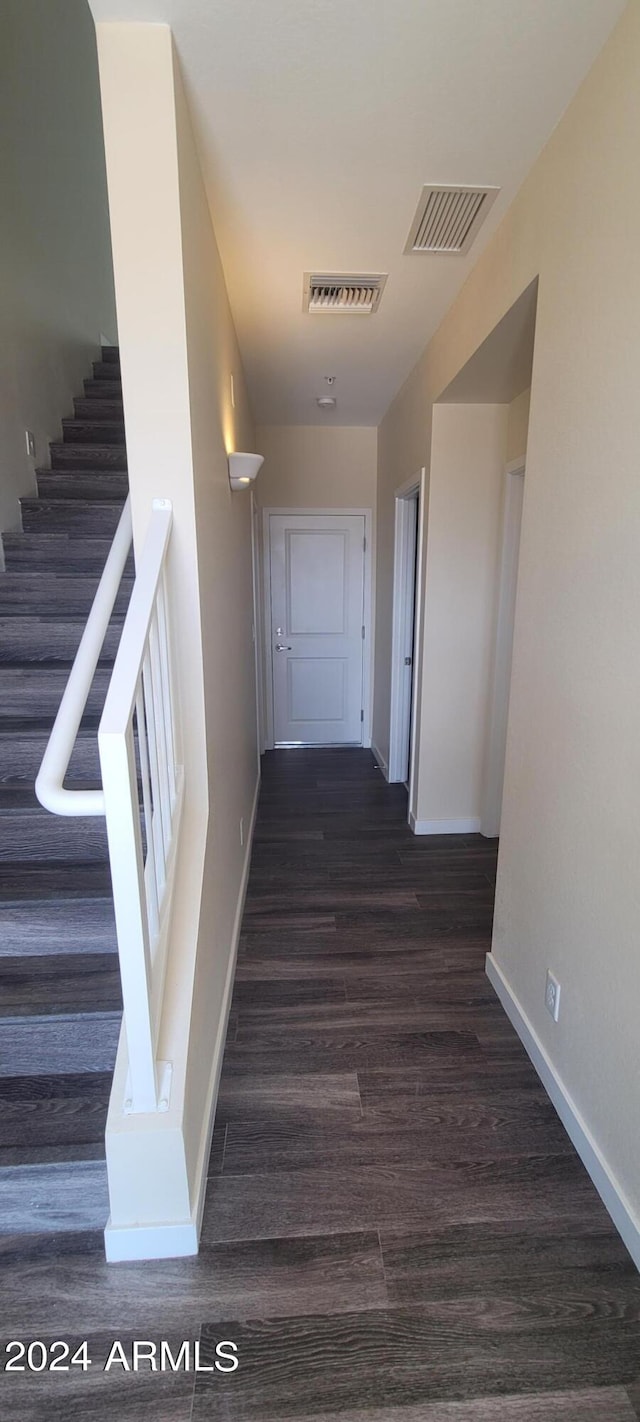 hall featuring visible vents, stairway, baseboards, and wood finished floors