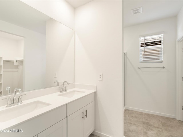 bathroom with vanity, walk in shower, and tile patterned flooring