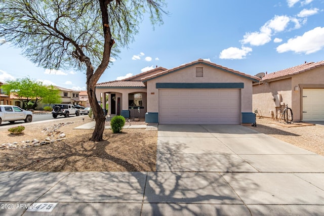 mediterranean / spanish-style home with a tiled roof, a garage, driveway, and stucco siding