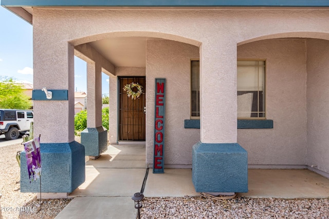 doorway to property featuring stucco siding