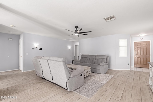 living room with wood finish floors, baseboards, ceiling fan, and visible vents