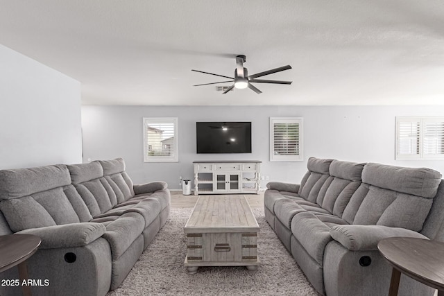 living area with light wood-style floors and a ceiling fan
