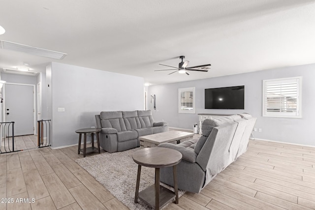 living room with a ceiling fan, baseboards, and wood tiled floor