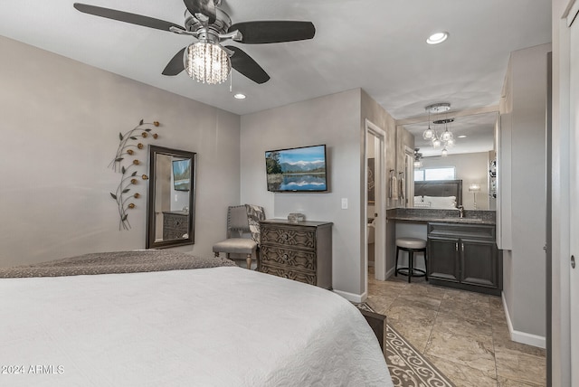 bedroom featuring ensuite bathroom, sink, and ceiling fan