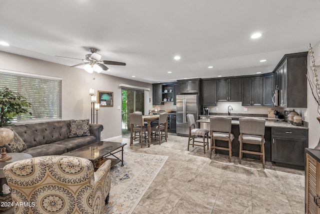 living room featuring ceiling fan, a healthy amount of sunlight, and sink