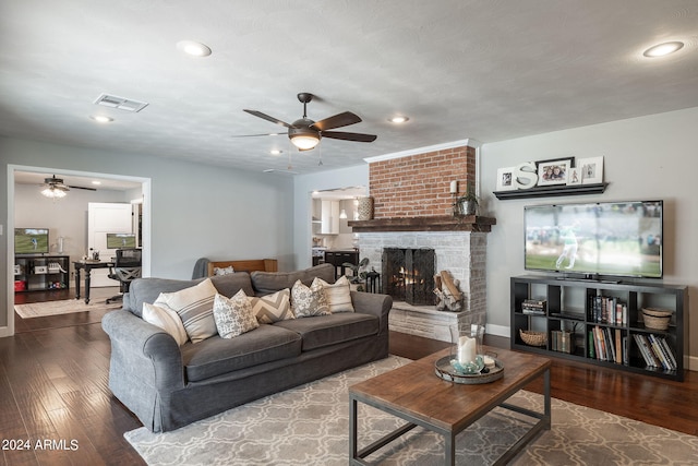 living area featuring recessed lighting, a large fireplace, visible vents, and hardwood / wood-style flooring