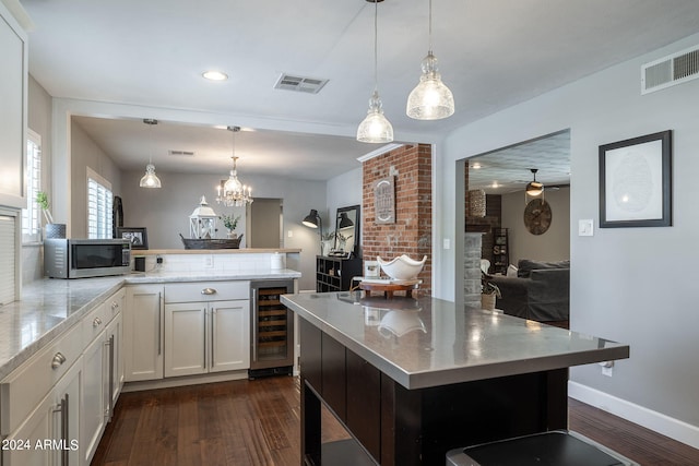 kitchen with visible vents, wine cooler, stainless steel microwave, and dark wood finished floors