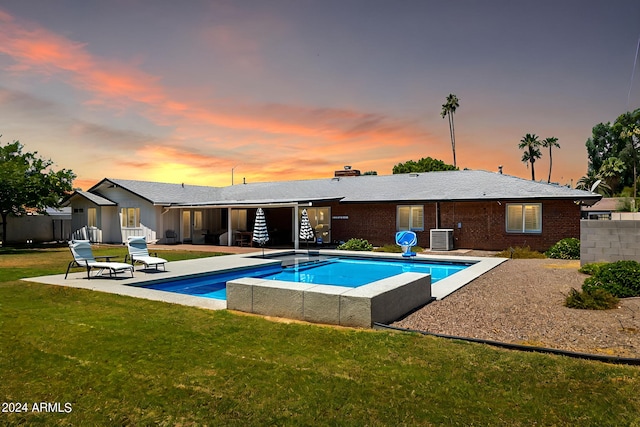 outdoor pool featuring a yard, a patio, cooling unit, and fence