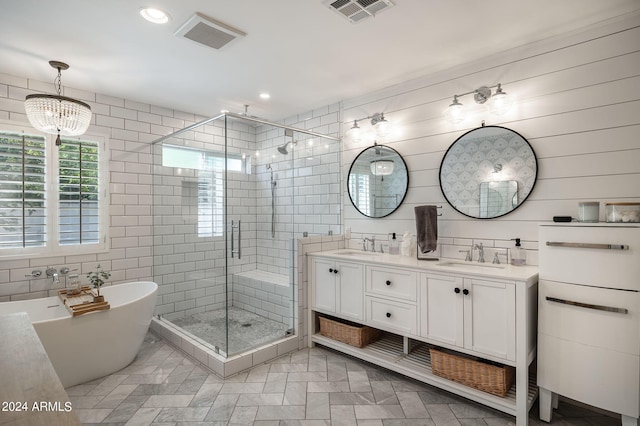 bathroom featuring double vanity, a shower stall, visible vents, and a sink