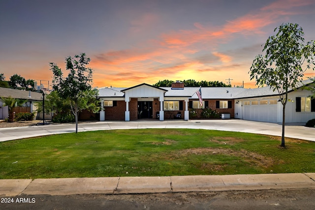 view of front of house featuring a garage, a lawn, and concrete driveway