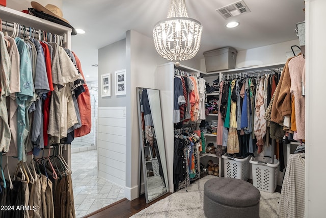 walk in closet with visible vents and a chandelier