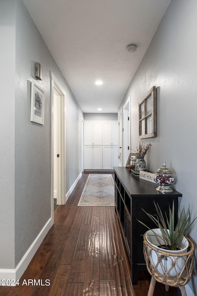 hall with dark wood-style flooring, recessed lighting, and baseboards