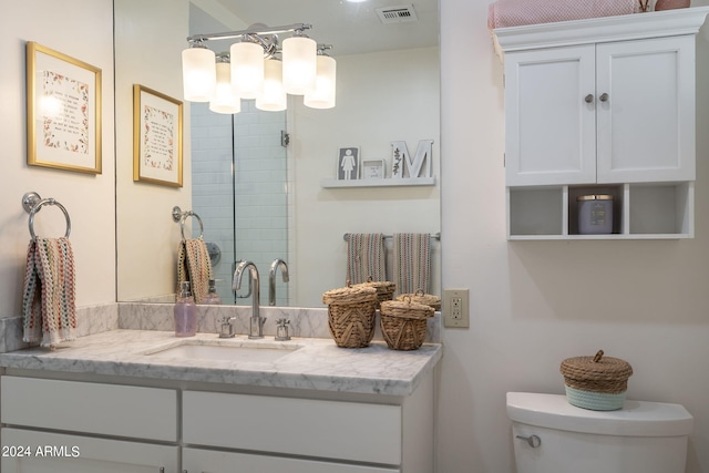 bathroom with toilet, a stall shower, vanity, and visible vents