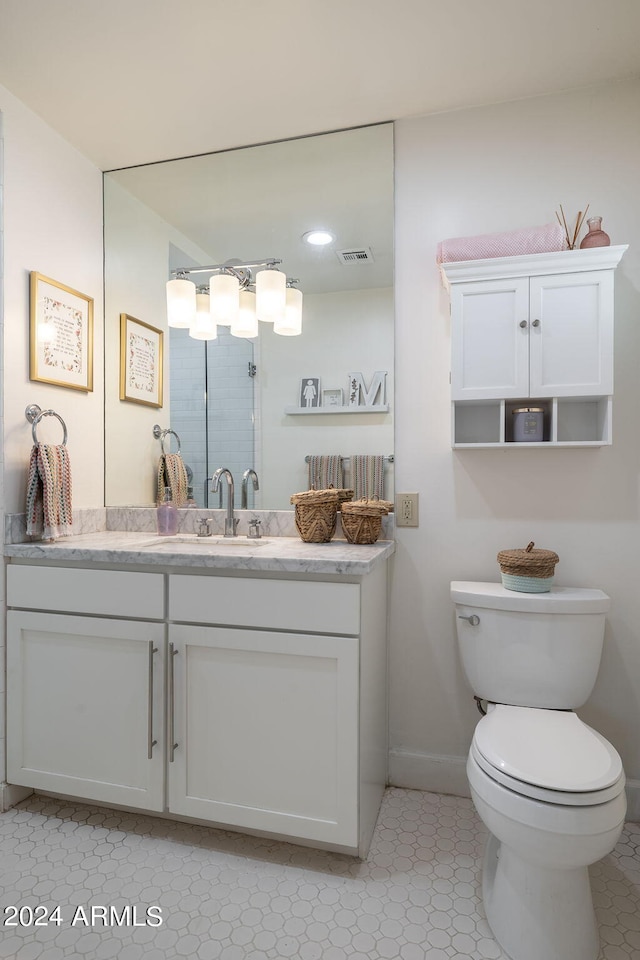 full bathroom featuring baseboards, visible vents, toilet, a shower with door, and vanity