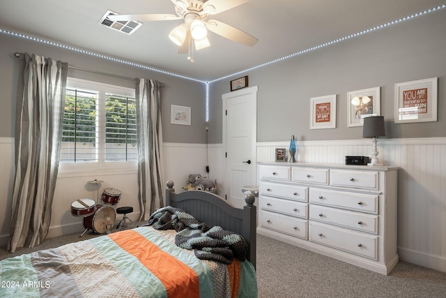 bedroom with light carpet, wainscoting, and visible vents