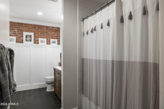 full bath featuring a shower with shower curtain, toilet, wainscoting, tile patterned flooring, and crown molding