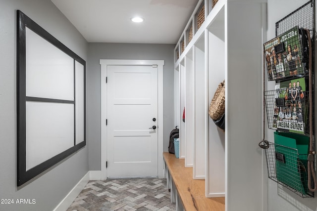 mudroom with brick floor, recessed lighting, and baseboards