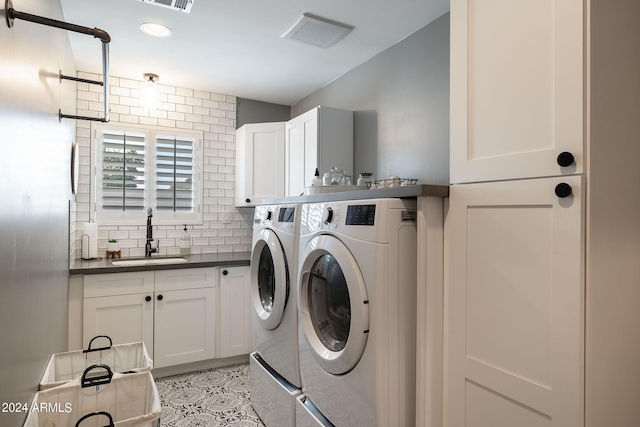 laundry room featuring cabinet space, visible vents, a sink, and independent washer and dryer