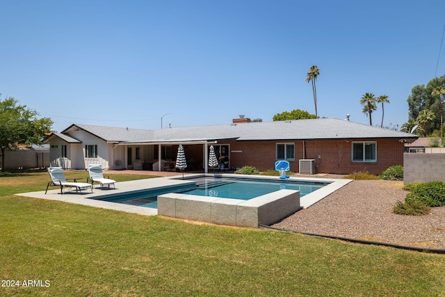 back of property featuring a lawn, a patio, fence, cooling unit, and brick siding