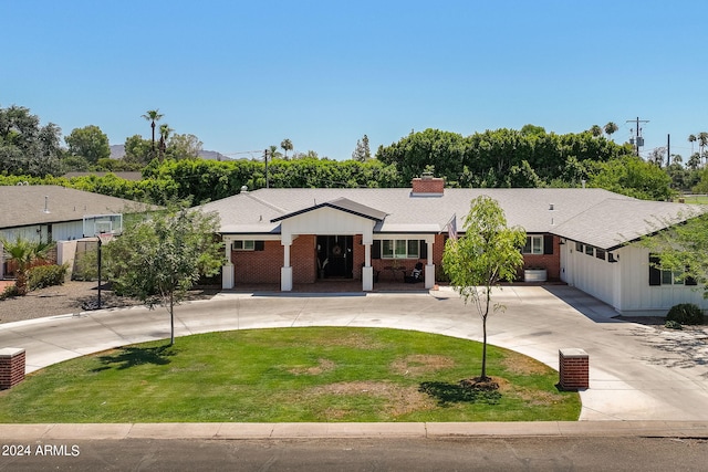 single story home with driveway, a shingled roof, a chimney, a front lawn, and brick siding