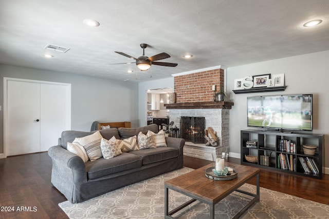 living room with recessed lighting, a brick fireplace, visible vents, and wood finished floors