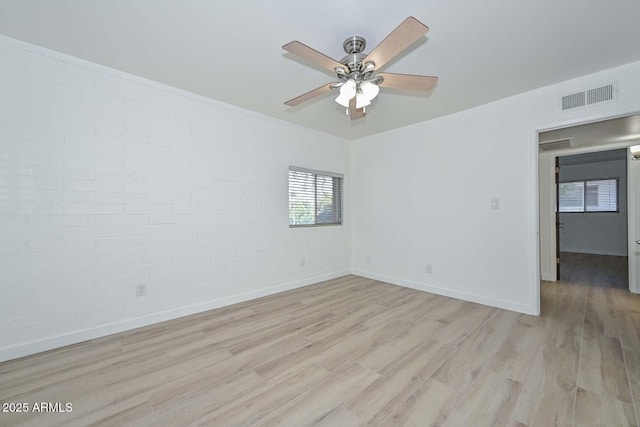 3637 E Monterosa St Unit 8, Phoenix, AZ 85018 - empty room with light wood finished floors, a ceiling fan, and brick wall