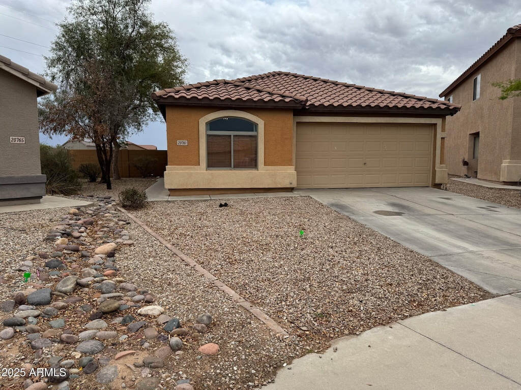 20761 N Herbert Ave, Maricopa, AZ 85138 - mediterranean / spanish home featuring a tiled roof, driveway, a garage, and stucco siding