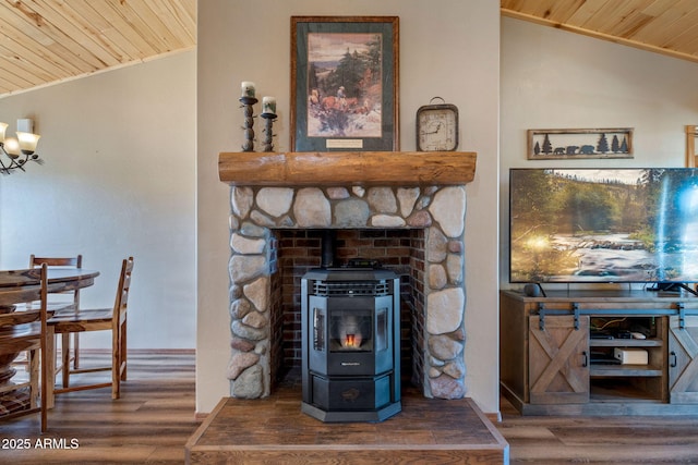 living area featuring wooden ceiling, wood finished floors, vaulted ceiling, ornamental molding, and a wood stove