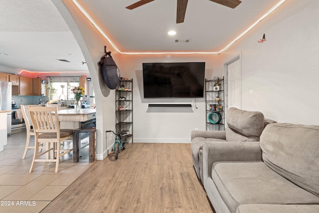 living room featuring light hardwood / wood-style floors and ceiling fan