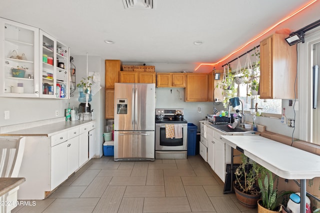 kitchen with appliances with stainless steel finishes, sink, and white cabinetry