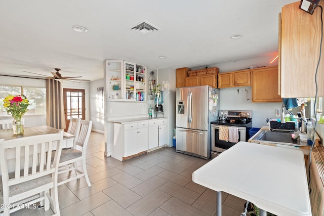 kitchen with sink, ceiling fan, stainless steel appliances, and white cabinets