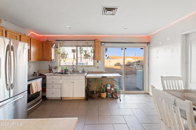 kitchen featuring stainless steel appliances, a textured ceiling, and sink