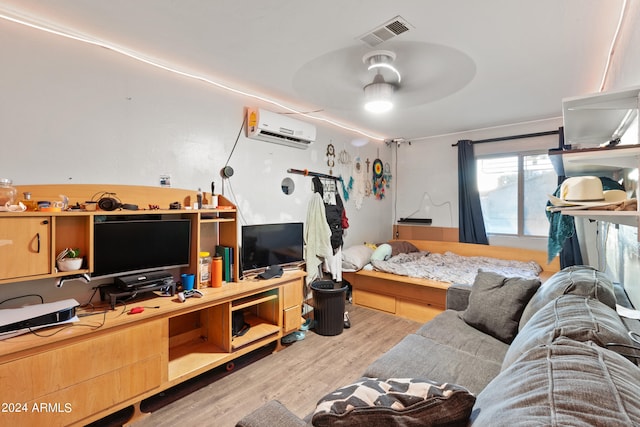 bedroom featuring light hardwood / wood-style flooring and a wall mounted air conditioner