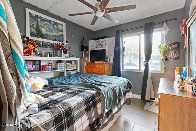 bedroom featuring a textured ceiling, light tile patterned flooring, and ceiling fan