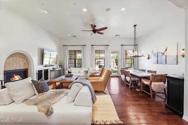 living room with dark wood-type flooring and ceiling fan with notable chandelier