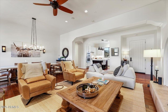 living room with ceiling fan with notable chandelier and light wood-type flooring