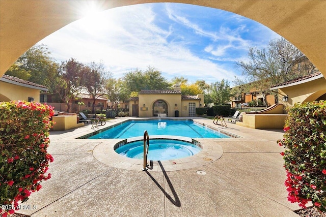 view of swimming pool featuring a community hot tub and a patio