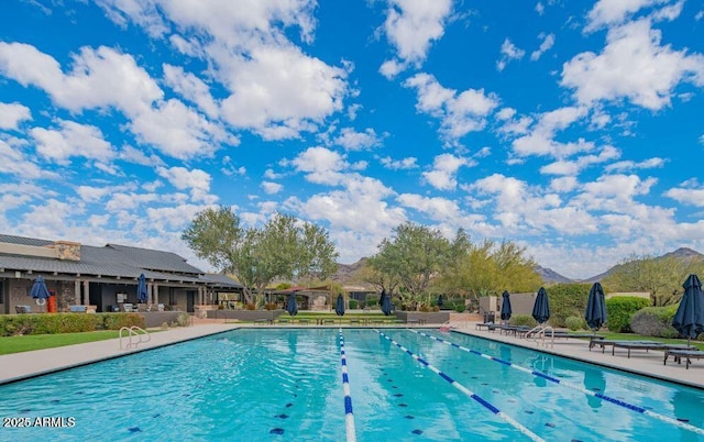 view of swimming pool featuring a patio and a mountain view