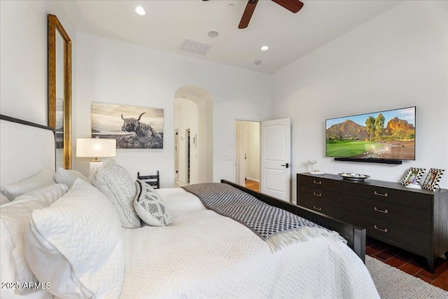 bedroom with ceiling fan, dark hardwood / wood-style flooring, and a high ceiling