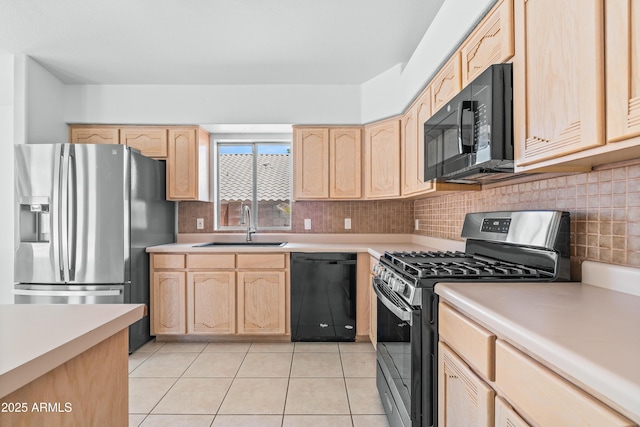 kitchen with a sink, light brown cabinetry, black appliances, and light countertops