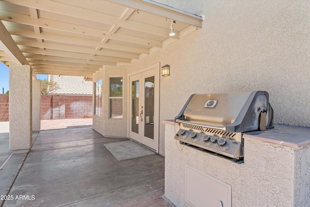 view of patio / terrace with an outdoor kitchen, fence, french doors, and a grill