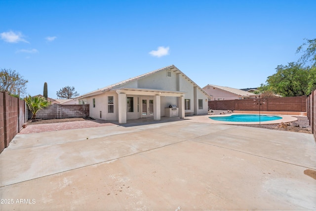 view of pool with a fenced in pool, a fenced backyard, a patio area, and french doors